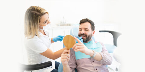 A dentist while ongoing dental extraction procedure with a man at dental office in Munster