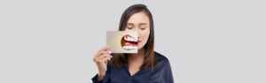 A girl holding receding gums poster in hand at family dental care
