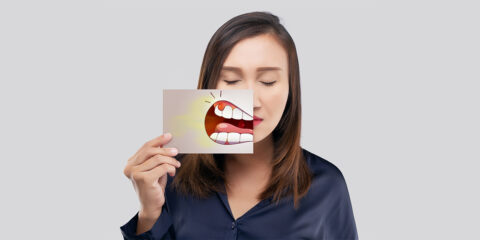 A girl holding receding gums poster in hand at family dental care